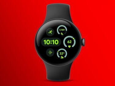 Auf dem Bild ist die Pixel Watch 3 von Google zu sehen. Die Smartwatch hat ein rundes, schwarzes Gehäuse mit einem farbigen Display, das die Uhrzeit sowie verschiedene Fitness- und Gesundheitsdaten wie Schritte, Herzfrequenz und Temperatur in grünem Text auf schwarzem Hintergrund anzeigt. Der Hintergrund des Bildes ist leuchtend rot, was die Uhr besonders hervorhebt.