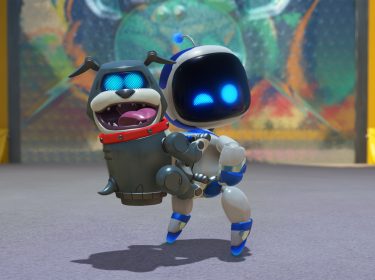 Auf dem Bild aus Astro Bot Test hält der kleine Roboter Astro Bot einen fröhlich aussehenden Roboter-Hund in seinen Armen. Beide haben leuchtend blaue Augen und wirken zufrieden. Der Hintergrund zeigt eine farbenfrohe, unscharfe Wand in einer futuristischen Umgebung. Astro Bot scheint sich auf einen spielerischen Moment zu freuen, während der Roboter-Hund mit offenem Mund glücklich aussieht. Die Szene wirkt freundlich und energiegeladen.