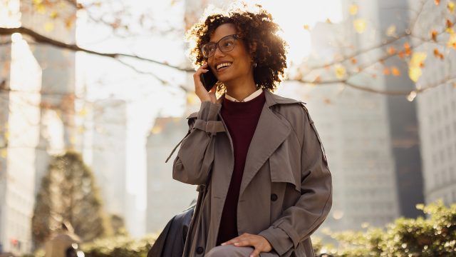 Auf dem Bild in dem Artikel zu den GigaMobil-Tarifen ist eine Frau mit Brille zu sehen, die lächelnd in einem herbstlichen Stadtpark telefoniert.