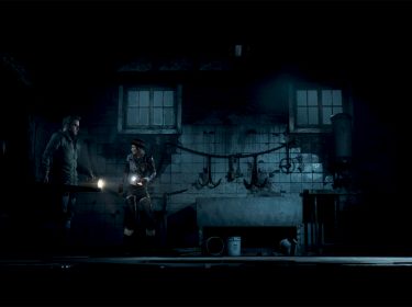Auf dem Bild aus Until Dawn Remake im Test befinden sich zwei Charaktere in einem dunklen, heruntergekommenen Raum. Beide halten Taschenlampen, die den schmutzigen Raum nur spärlich beleuchten. An der Wand hängen Haken und Werkzeuge, die eine bedrohliche Atmosphäre schaffen. Die Charaktere wirken angespannt und vorsichtig, als ob sie auf der Suche nach etwas oder jemandem sind, was zur unheimlichen Stimmung des Horrorspiels beiträgt.