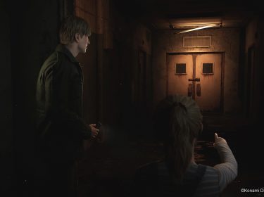 Auf dem *Artikelbild vom Silent Hill 2 Remake-Tipps-Artikel* sieht man den Protagonisten James Sunderland in einem dunklen, heruntergekommenen Korridor, begleitet von einem jungen Mädchen, das auf eine verschlossene, rostige Tür am Ende des Flurs zeigt. Die düstere Beleuchtung und der abgeblätterte Putz der Wände verstärken die unheimliche Atmosphäre des Ortes. James hält eine Taschenlampe in der Hand und blickt ernst in Richtung der Tür, während das Mädchen eine mögliche Gefahr andeutet.