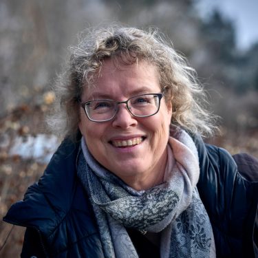 Kinderbuchautorin Katja Brandis lächelt in die Kamera.