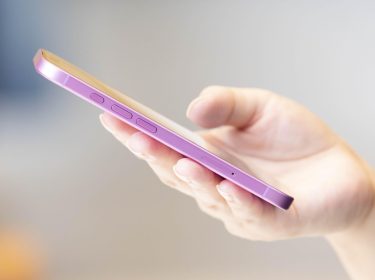 Menschliche Hand hält das iPhone 16.