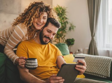 Ein glückliches Paar surft mit einem Tablet im Internet