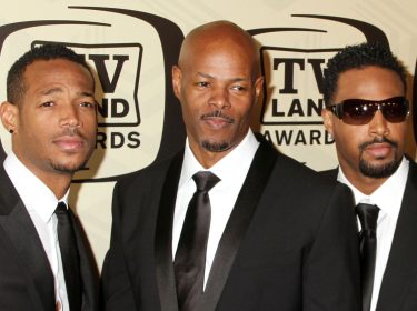 Auf dem Bild zum neuen Scary Movie Film sind die drei Wayans Brüder zu sehen, die in dunklen Anzügen vor einer TV Land Awards Wand posieren. Links steht Marlon Wayans mit leichtem Lächeln, in der Mitte Keenen Ivory Wayans mit kühlem Blick, und rechts Shawn Wayans mit Sonnenbrille. Die Brüder wirken stilvoll und selbstbewusst.