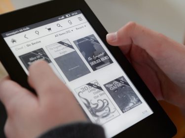 Zwei Hände halten ein Kindle-Gerät