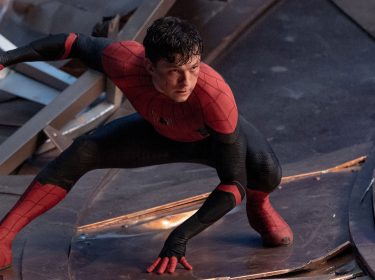 Auf dem Bild zu Spider-Man 4 ist Tom Holland als Spider-Man in einer angespannten Pose zu sehen. Er kniet kampfbereit auf dem Boden eines zerstörten, metallischen Untergrunds und blickt entschlossen nach vorne. Sein roter und schwarzer Anzug ist leicht beschädigt, was auf einen intensiven Kampf hindeutet. Die Szene wirkt dynamisch und zeigt Spider-Mans Entschlossenheit und Ausdauer im Kampf gegen Gefahren.
