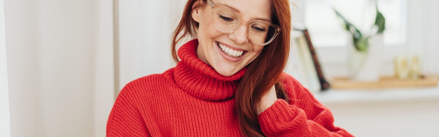 Auf dem Bild in dem Artikel zur Rufnummermitnahme bei Vodafone ist eine Frau mit Brille und einem Handy zu sehen.