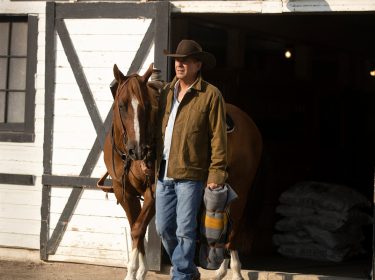 Auf dem Bild in dem Artikel über die Yellowstone Reihenfolge, ist zu sehen, wie ein Mann mit einem Pferd aus einem Stall läuft.