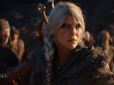 Auf dem Bild zu The Witcher 4 ist Ciri mit ihrem markanten silbernen Haar zu sehen, das zu einem geflochtenen Zopf gebunden ist. Sie trägt eine detaillierte, mittelalterlich inspirierte Rüstung mit Pelzbesatz. Ihr Gesichtsausdruck ist ernst und entschlossen, während sie sich in einer Gruppe von Personen befindet, die im Hintergrund unscharf dargestellt sind. Die Szene wirkt atmosphärisch und dramatisch.