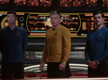 Auf dem Bild in den GigaTV-Highlights im Januar 2025 ist eine Szene aus der Serie Star Trek: Strange New Worlds zu sehen. Im Zentrum steht Captain Christopher Pike, gespielt von Anson Mount, in einer gelben Uniform, flankiert von Spock (Ethan Peck) und George Samuel Kirk (Dan Jeannotte), beide in blauen Uniformen.