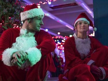 Connor Swindells und Olivia Holt in Santa-Claus-Kostümen im Weihnachtsfilm 