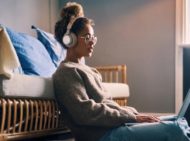 Eine junge Frau sitzt und streamt Musik