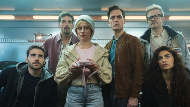 Die Crew von Berlin steht versammelt vor einem Gemälde.