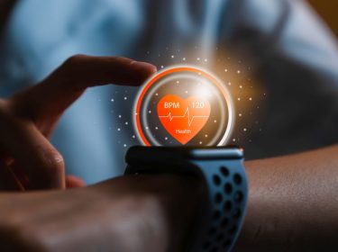 Frau tippt auf ihre Smartwatch.