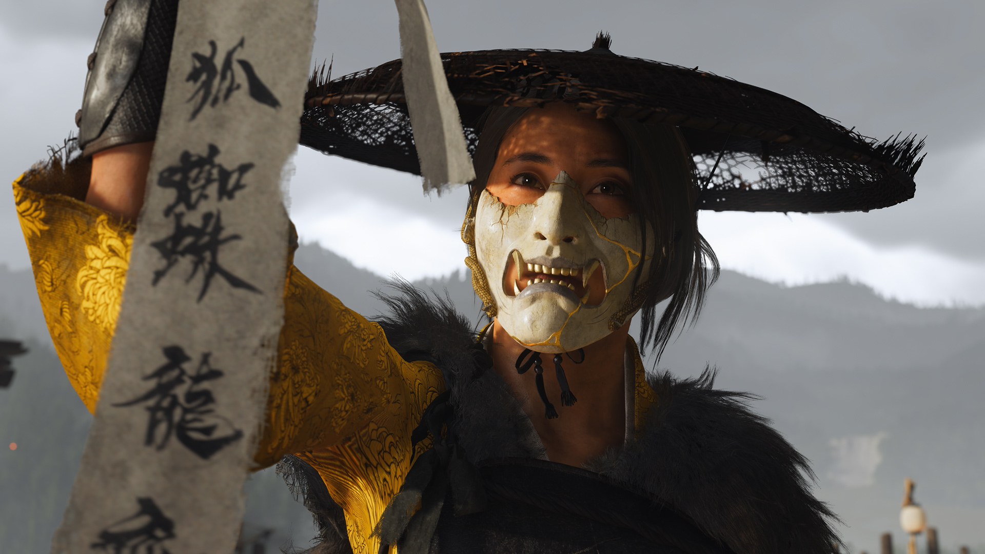 Auf diesem Bild aus dem Spiel Ghost of Yotei ist eine Charakterin in einem auffälligen gelben Gewand mit floralen Mustern zu sehen. Sie trägt eine Maske und einen Strohhut. In ihrer Hand hält sie ein Schriftband mit Schriftzeichen.