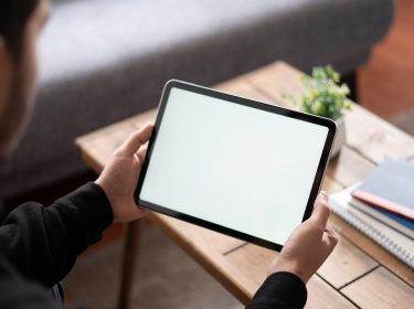 Ein Mann hält ein Tablet in seinen Händen