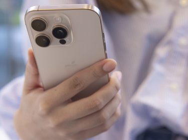 Kundin hält im Apple Store ein iPhone 16 Pro in Weiß in der Hand