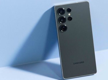 Galaxy S25 Ultra lehnt an eine blaue Wand an.