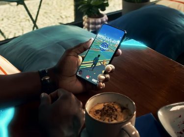 Eine Person hält ein Smartphone in der Hand und spielt Pokémon GO