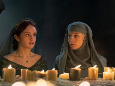 In dieser Szene aus House of the Dragon Staffel 2 sitzen Alicent Hohenturm, gespielt von Olivia Cooke, und Rhaenyra Targaryen, dargestellt von Emma D’Arcy, schweigend vor einem Altar mit brennenden Kerzen. Beide wirken angespannt und nachdenklich – ein stiller, aber intensiver Moment, der die Spannung für House of the Dragon Staffel 3 weiter aufbaut.