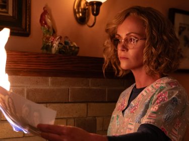 Paramount+ beste serien zeigt in dieser Szene Christina Ricci als Misty aus der Serie Yellowjackets. Sie steht vor einem Kamin und hält ein brennendes Foto in der Hand.