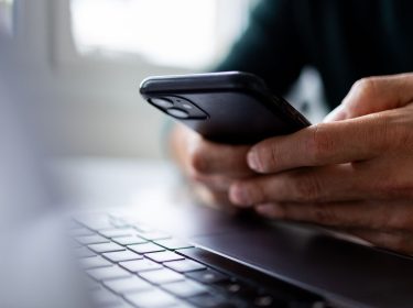 Eine Person hält ein Smartphone in der Hand.