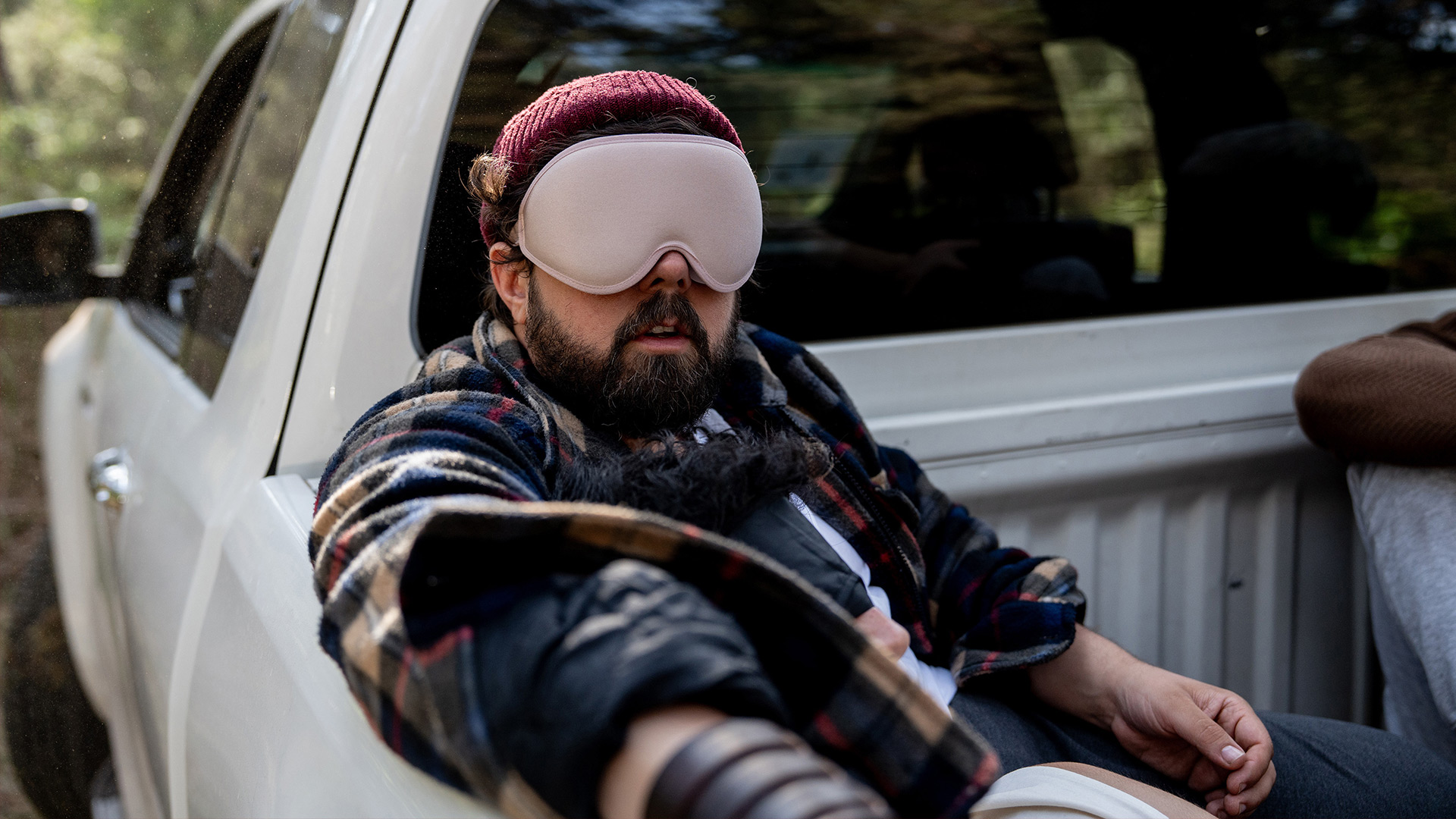 Auf dem Bild aus Werwölfe in der ARD sitzt ein Mann mit Bart, Augenmaske und Mütze auf der Ladefläche eines weißen Pick-ups.