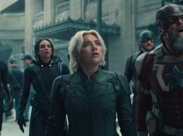 Auf diesem Bild zur Thunderbolts Kritik sind fünf zentrale Charaktere aus dem Marvel-Film Thunderbolts zu sehen. Im Vordergrund steht Yelena Belova, gespielt von Florence Pugh, mit entschlossenem Blick nach oben. Neben ihr sind Ghost (Hannah John-Kamen), Bucky Barnes (Sebastian Stan), John Walker (Wyatt Russell) und Red Guardian (David Harbour) in Einsatzmontur zu sehen. Die Szene wirkt angespannt und dramatisch, was durch die ernsten Gesichtsausdrücke und die dystopische Stadtkulisse verstärkt wird.