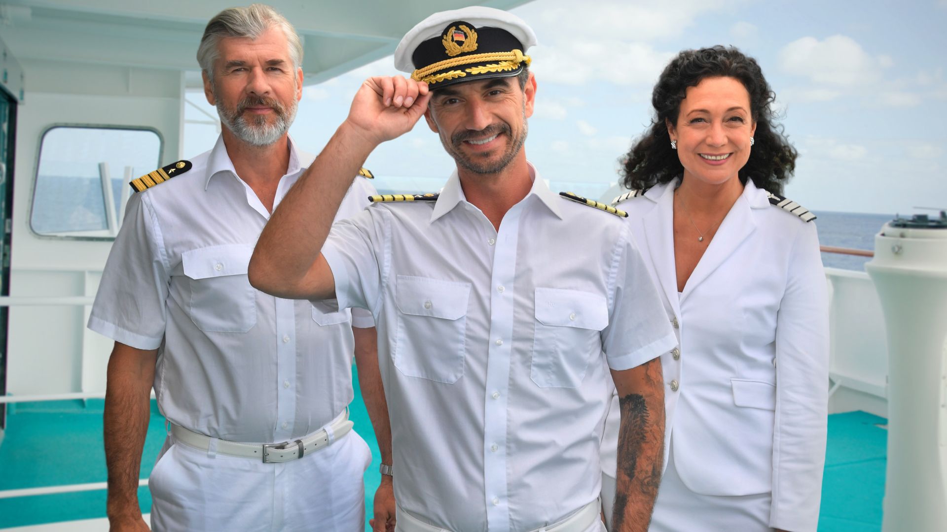 Daniel Morgenroth, Florian Silbereisen und Barbara Wussow posieren für das ZDF in ihren Kostümen für "Das Traumschiff"