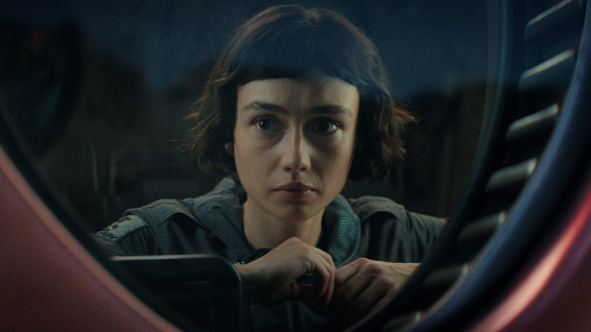 In dieser Szene der Alien: Earth Serie ist Wendy, gespielt von Sydney Chandler, durch ein rundes Fenster hindurch zu sehen
