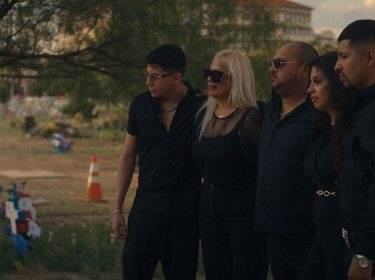 Fünf Personen stehen trauernd vor einem Grab.