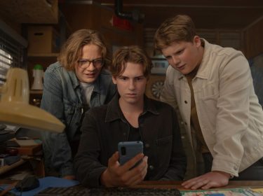 Im Bild in den GigaTV-Highlights im Juni 2025 sind die drei ??? in einer spannenden Szene aus dem Film „Die drei ??? und der Karpatenhund“ zu sehen. Justus (Julius Weckauf), Peter (Nevio Wendt) und Bob (Levi Brandl) schauen konzentriert auf ein Smartphone, während sie sich in einem vollgestellten Ermittlungsbüro befinden