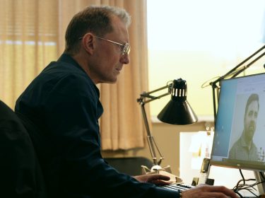 Peter Eggers sitzt in einer Szene von 