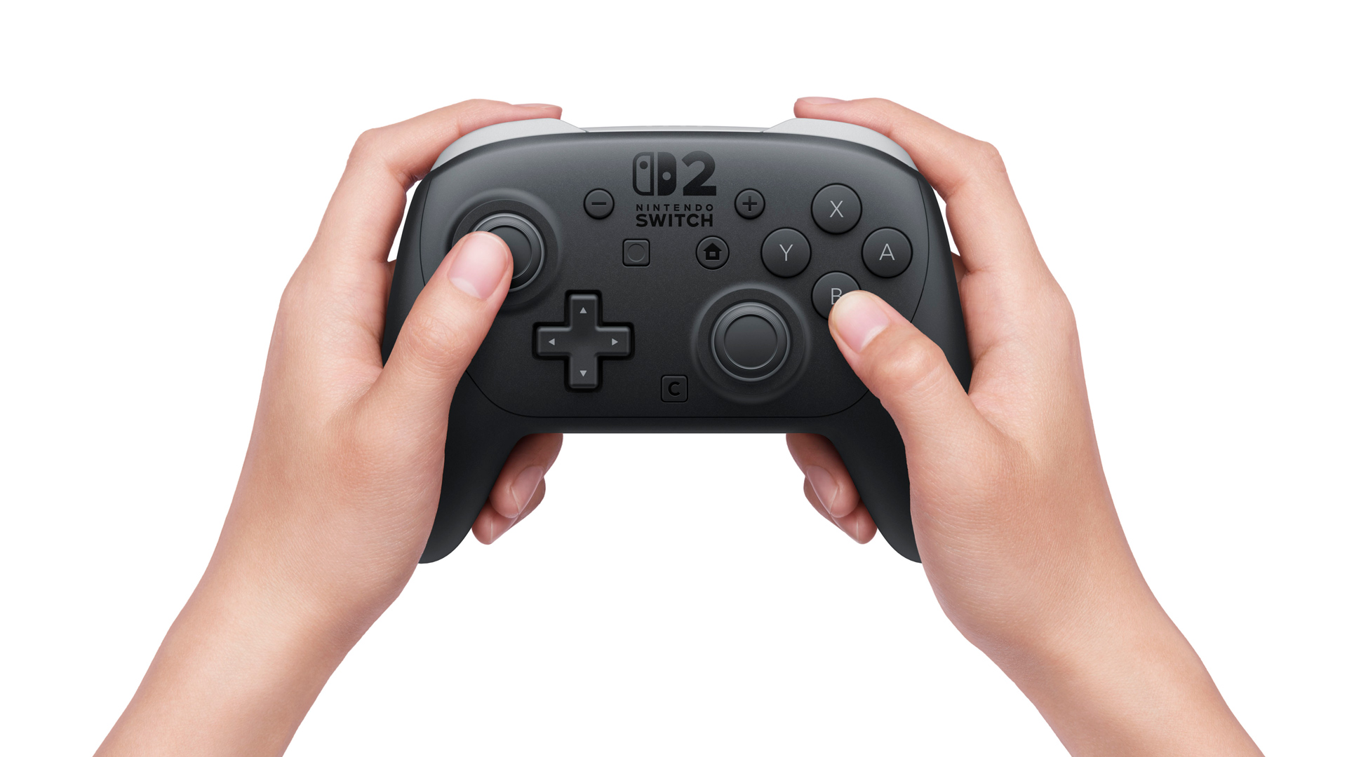 Das Bild zeigt zwei Hände, die den neuen Pro Controller der Nintendo Switch 2 halten. Im Zentrum des Controllers ist das Switch-2-Logo gut sichtbar. Das Design ist ergonomisch und wirkt robuster als beim Vorgängermodell. Diese Ansicht verdeutlicht gezielt die Switch 2 vs. Switch 1 Unterschiede bei der Formgebung und Tastenanordnung.