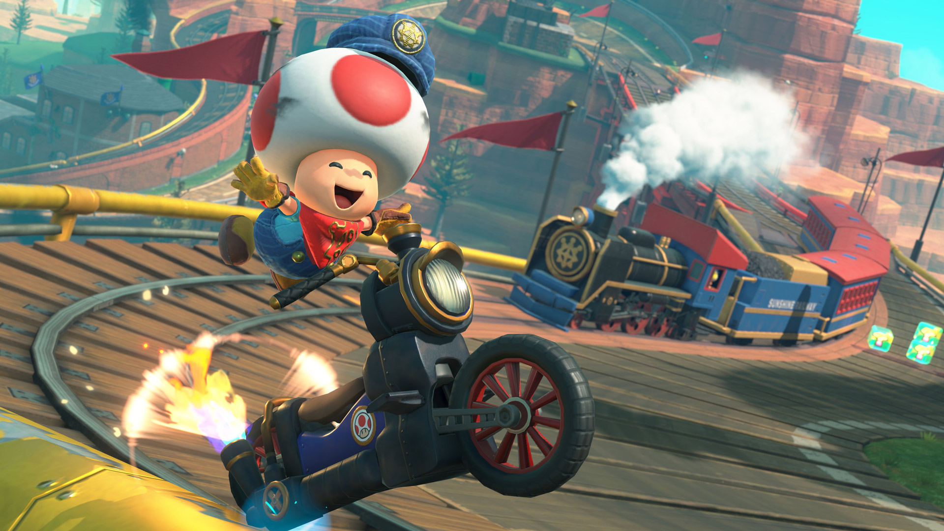 Auf dem Bild zu Mario Kart World Tipps springt Toad in einer Lokführer-Uniform fröhlich von seinem Motorrad ab, während im Hintergrund eine bunte Dampflok durch eine kurvige Bergstrecke fährt. Die Szene ist voller Bewegung, mit glühenden Reifen, Schienen und Items – sie vermittelt Abenteuerlust und den spaßigen Chaos-Faktor von Mario Kart.