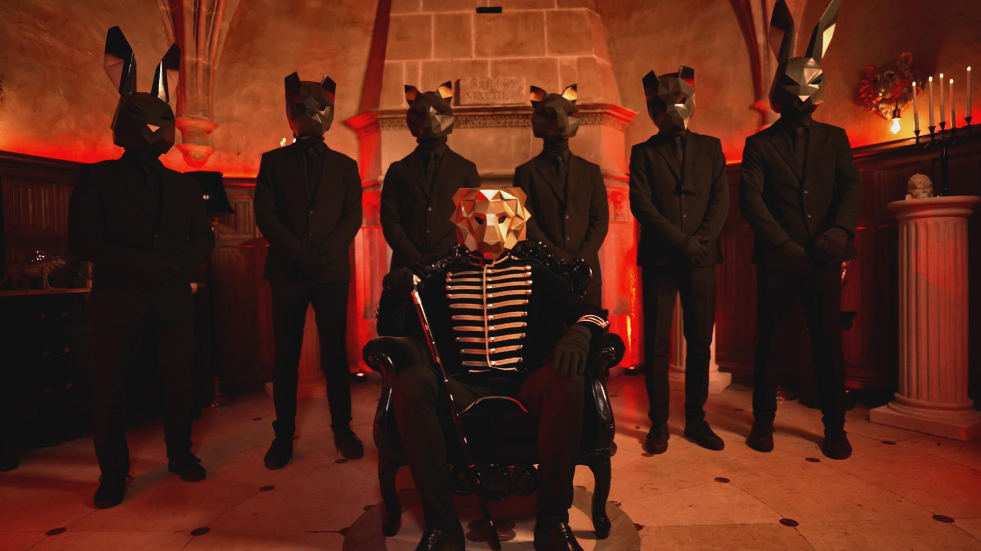Symbolbild aus The 50 Staffel 3: Der Spielleiter mit goldener Löwenmaske sitzt in einem prunkvollen schwarzen Thron, flankiert von sechs maskierten Wächtern in schwarzen Anzügen. Die animalischen Masken – darunter Hasen- und Katzenköpfe – wirken bedrohlich. Die düstere, rot beleuchtete Kulisse verstärkt die mysteriöse und autoritäre Atmosphäre der Reality-Serie The 50 Staffel 3.