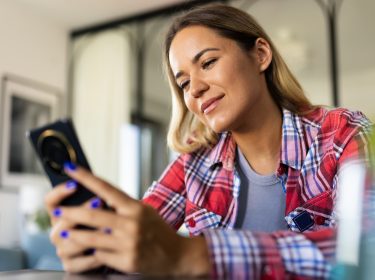 Eine Frau schaut auf ihr Smartphone.