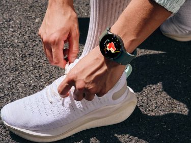 Mann mit Galaxy Watch am Arm bindet seine Schuhe zu.