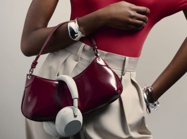 Frau trägt Sony-Kopfhörer über ihrer Handtasche.