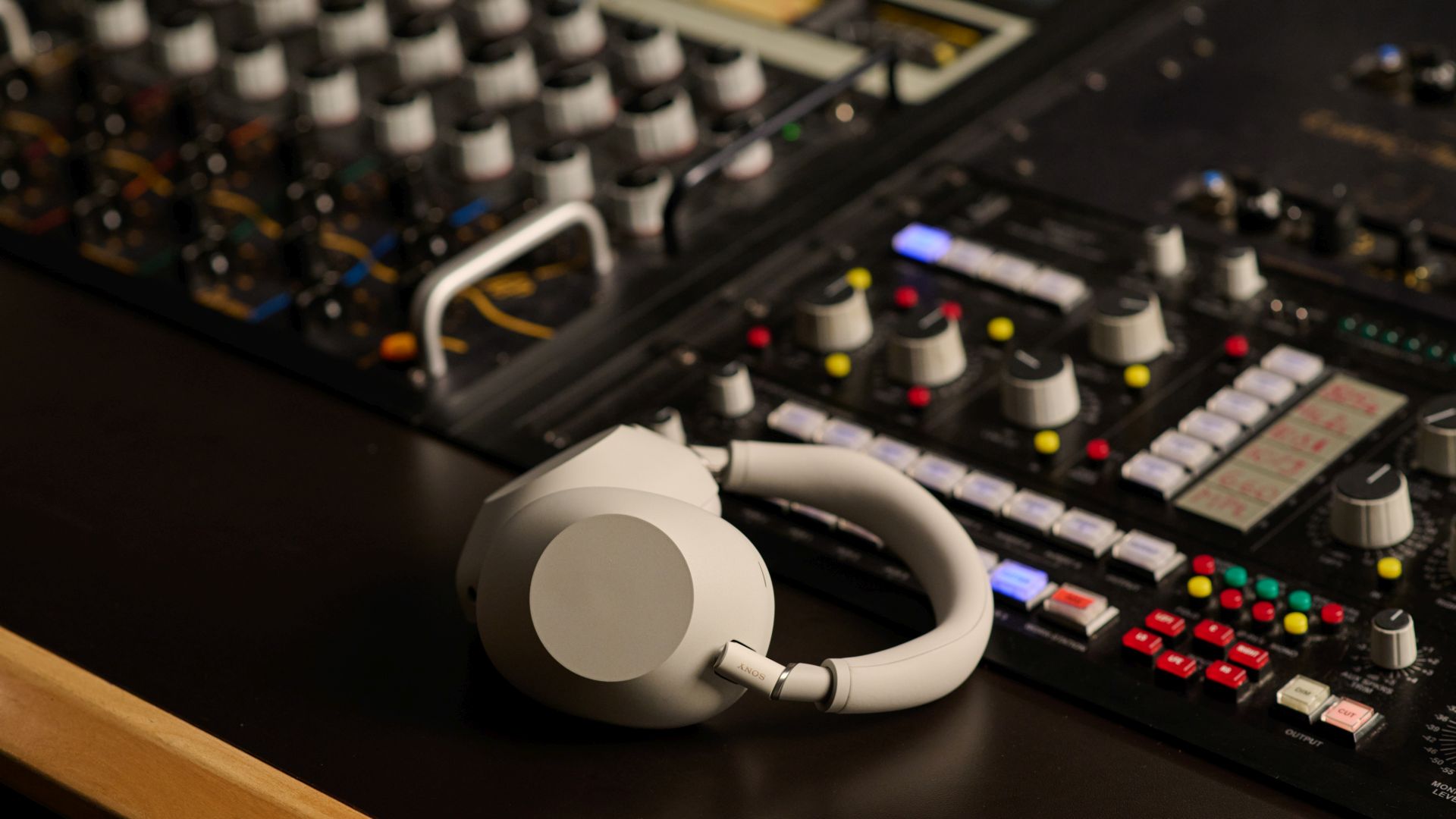 Die Sony WH-1000XM6 liegen auf einem Mischpult.