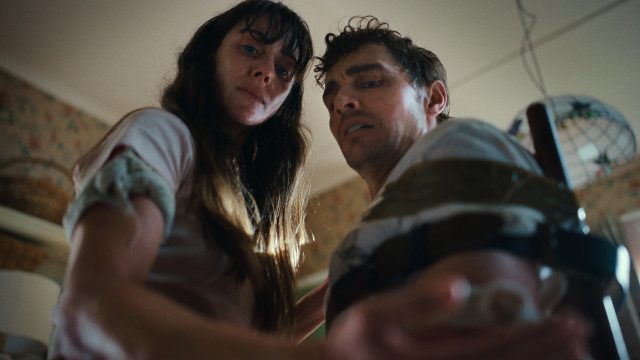 Allison Brie und Dave Franco in Togehter: Eine junge Frau und ein junger Mann stehen nah beieinander und blicken schockiert nach unten.