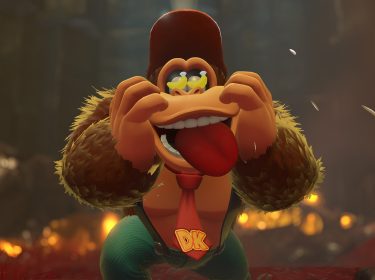 In diesem Bild aus einem der neuen Donkey Kong-Spiele streckt Donkey Kong seine Zunge heraus und zieht eine Grimasse. Er trägt eine rote Krawatte mit den Initialen „DK“.