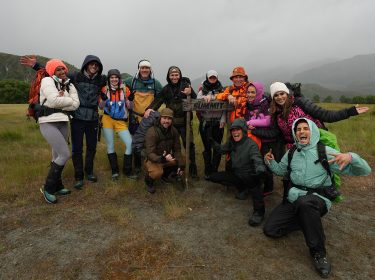 Auf dem Bild zur Reality-Show The Summit stehen die Teilnehmer*innen Cecilia Asoro, Flying Uwe, Klaudia Giez, Ansgar Brinkmann, Felix von Jascheroff, Serkan Yavuz, Julia Römmelt, Matthias Mangiapane, Giulia Siegel, Emmy Russ, Tanja Tischewitsch und PatroX lachend in einer Berglandschaft. Sie posieren stolz vor einem Schild mit der Aufschrift „Summit“ und wirken energiegeladen und siegessicher.
