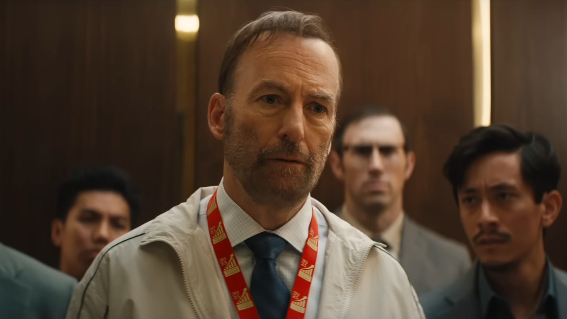 Bob Odenkirk in Nobody 2: Ein Mann steht in einem Aufzug mit mehreren Männern, die ihn aggressiv anschauen.