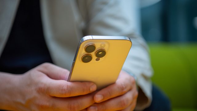 Ein Mann hält ein iPhone in den Händen.