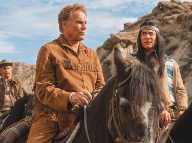 Auf diesem Bild aus dem Film „Das Kanu des Manitu“ sind Christian Tramitz als Ranger und Michael Bully Herbig als Abahachi zu sehen. Beide sitzen auf Pferden in einer felsigen Landschaft und blicken ernst nach vorne. Im Hintergrund reitet ein weiterer Cowboy. Die Szene wirkt angespannt und dramatisch. Perfekt für eine visuelle Einordnung zur Das Kanu des Manitu Kritik.
