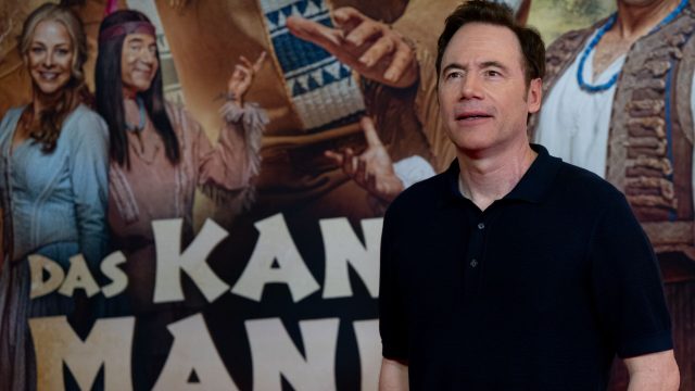 Michael Bully Herbig steht vor einem Poster seines Films "Kanu des Manitu"