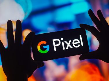 Als Schatten dargestellte Hände halten auf einem Event ein Smartphone mit Pixel-Logo hoch.