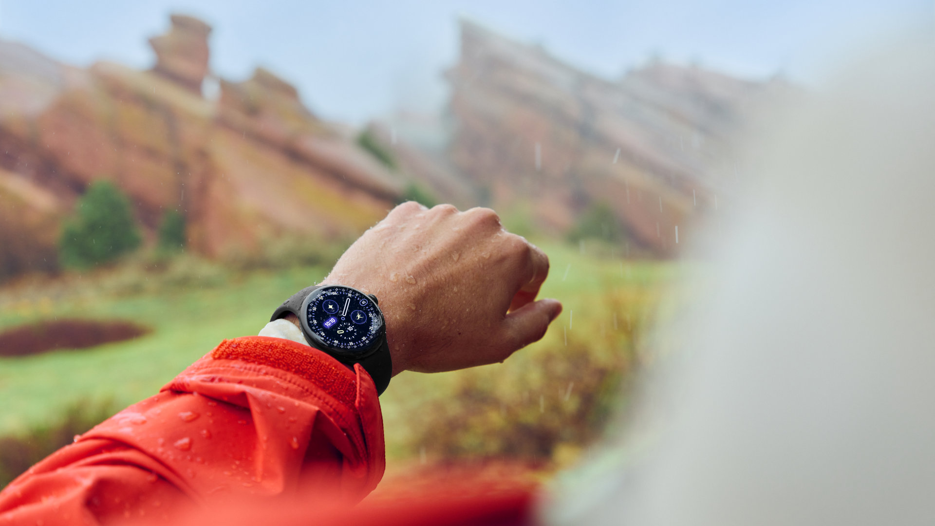 Nahaufnahme einer Pixel Watch 4 am Handgelenk - es regnet.